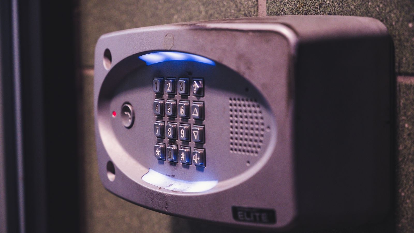 Illuminated security keypad mounted beside a door for keyless entry