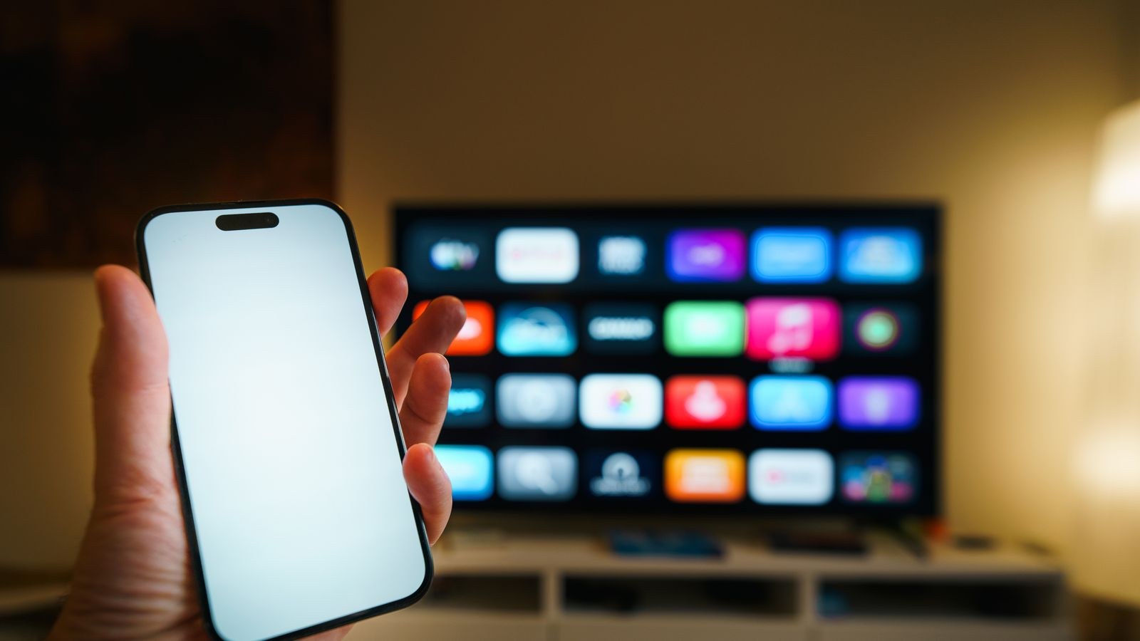 Smartphone and smart TV showing streaming apps side by side in a cozy living room