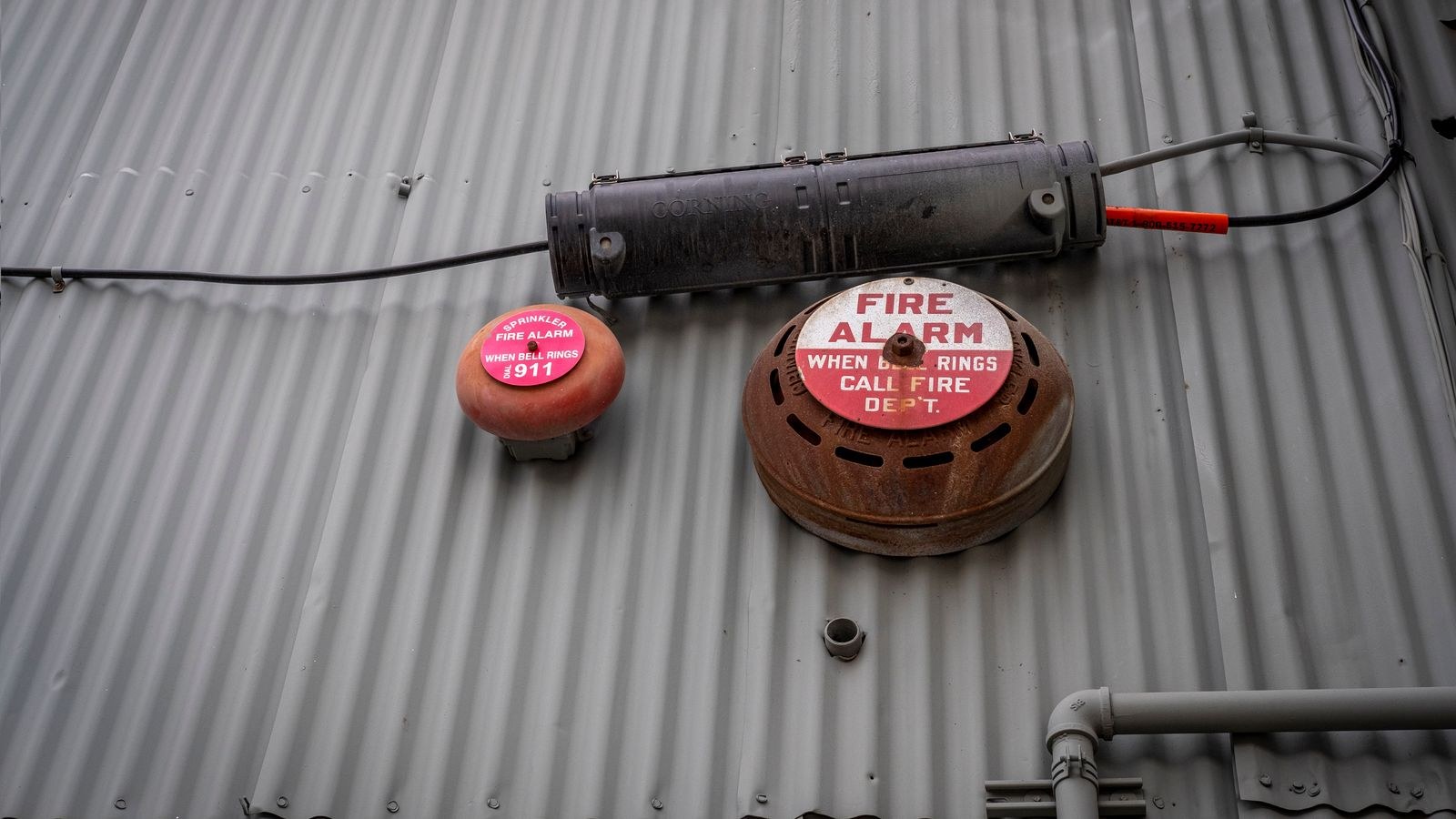 Wall mounted fire alarm device illustrating building code safety requirements