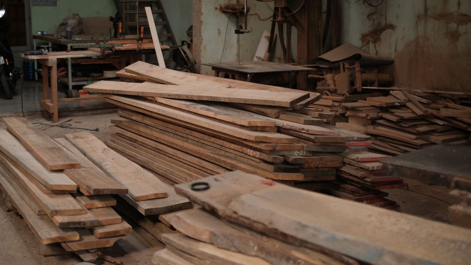 Stack of wooden planks in a workshop showing hardwood used for furniture frames