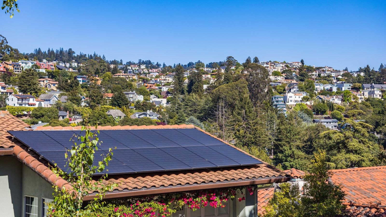 Solar panels on a suburban house roof powering outdoor security equipment