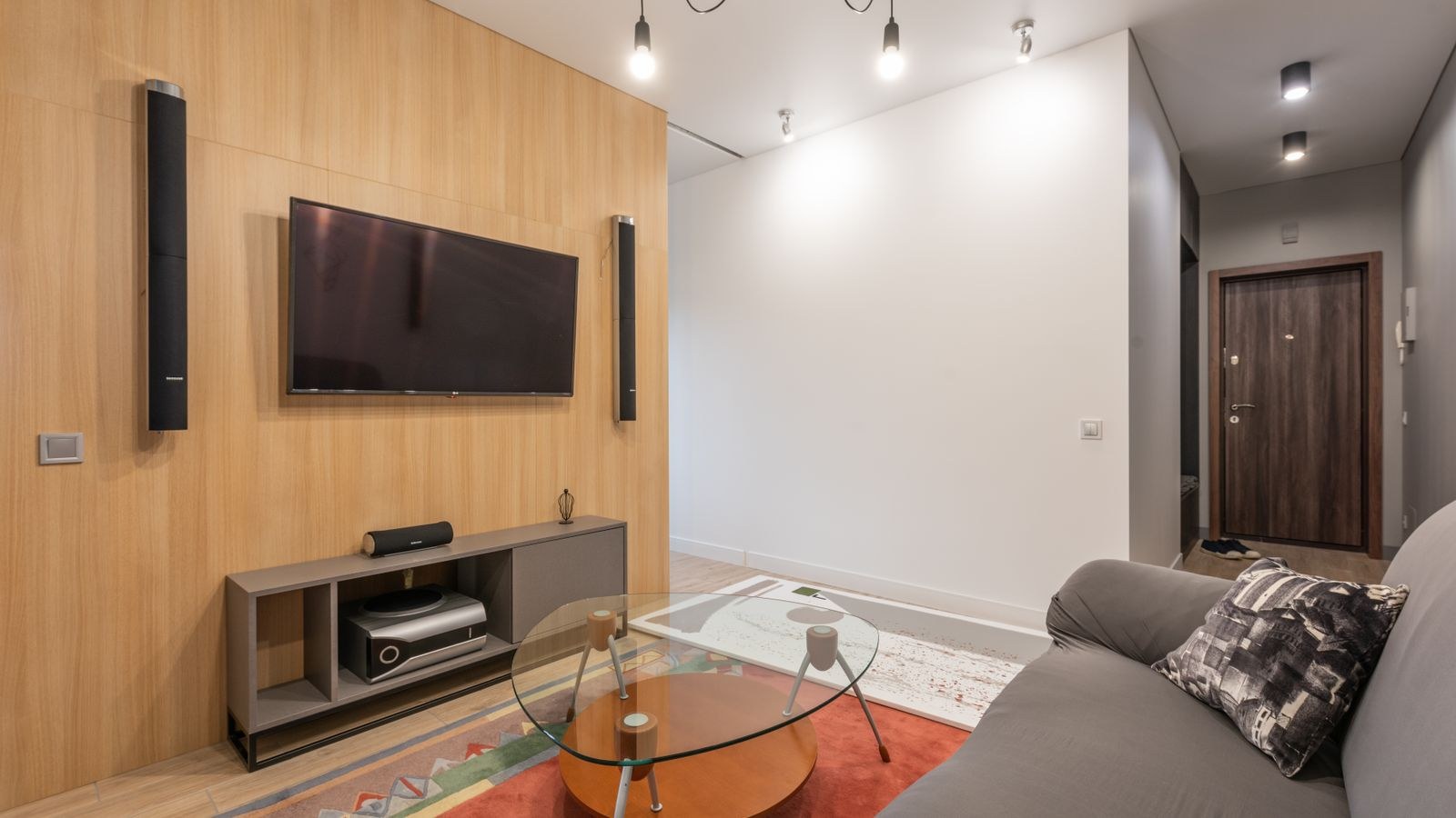 Contemporary apartment living room with a TV cabinet and floor standing speakers