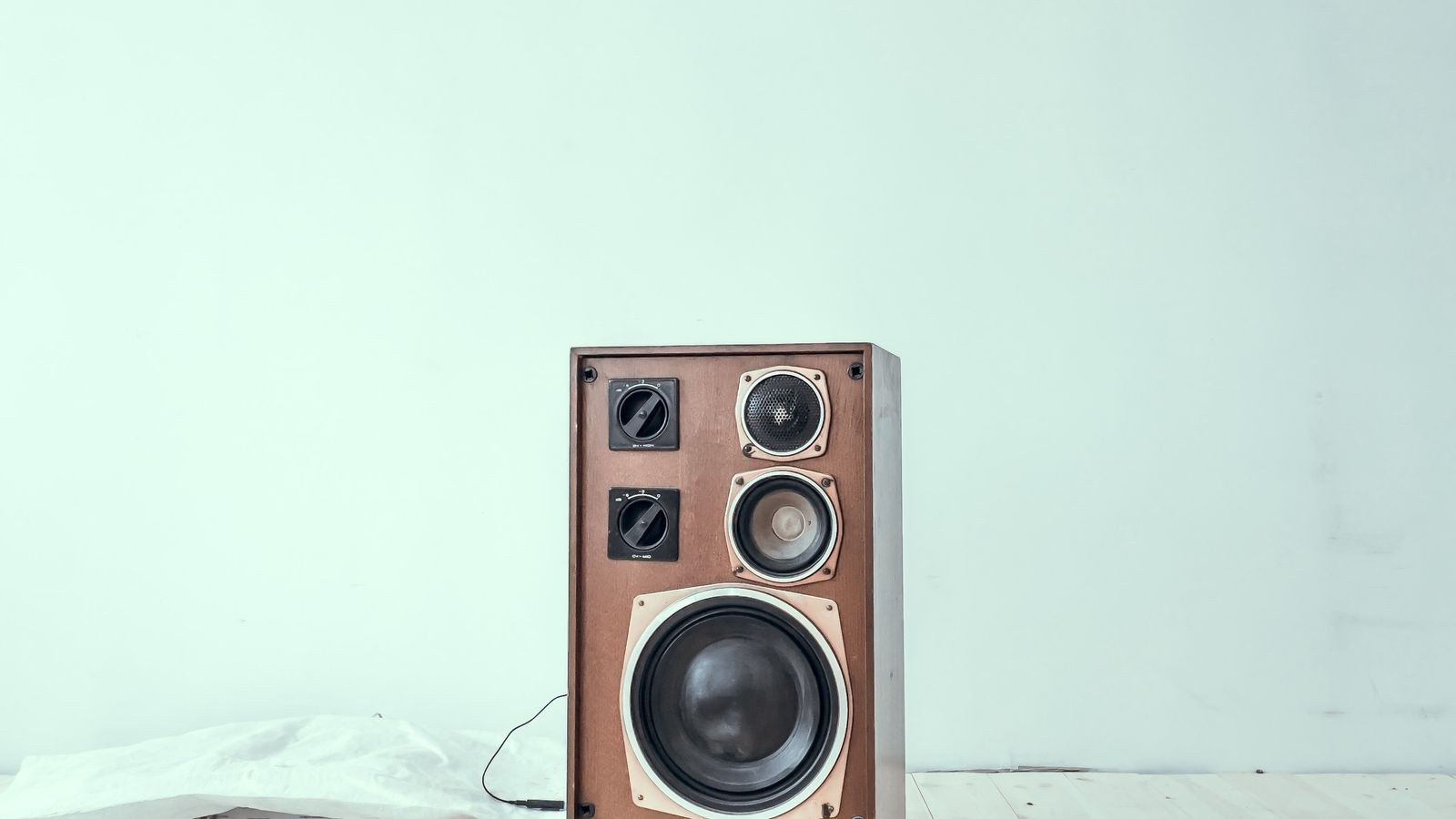 Vintage wooden loudspeaker placed on a light wooden floor
