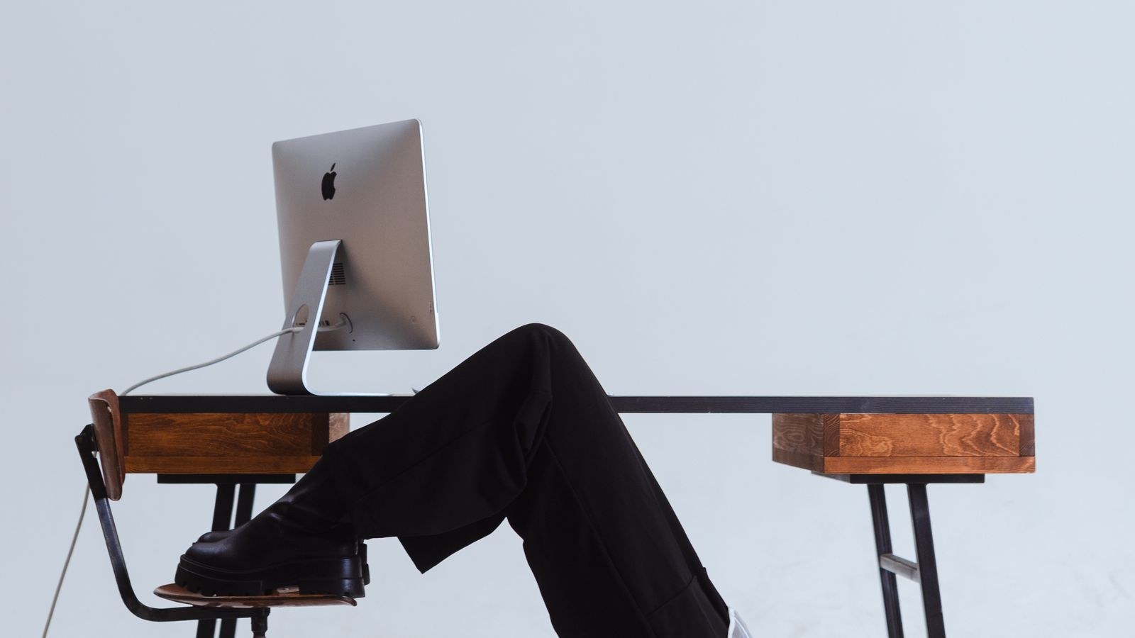 Woman stretching backward over an office chair to relieve tight hips and lower back
