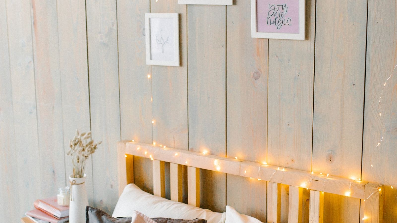 Bedroom wall decorated with warm indoor string lights above a bed
