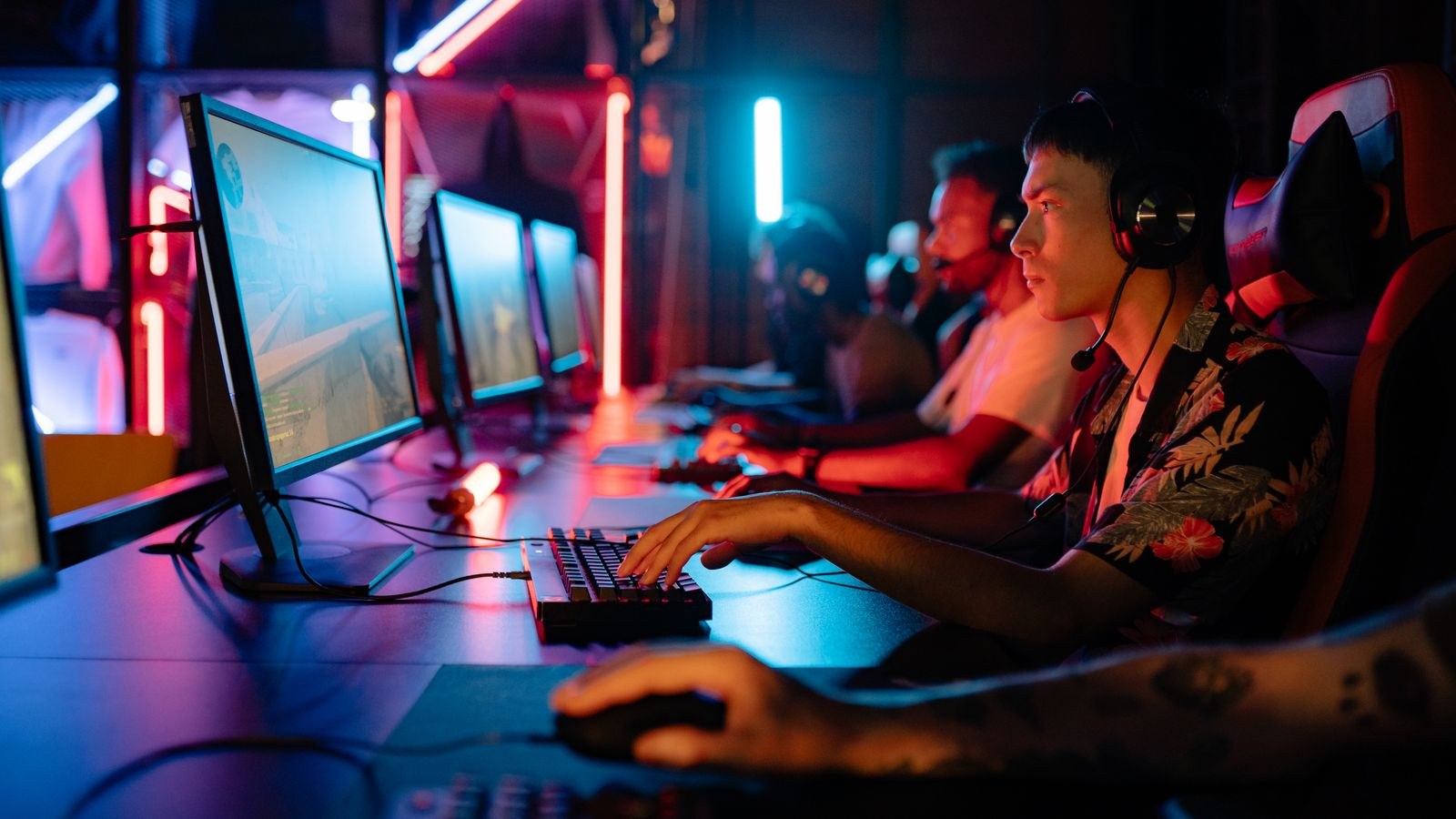 Group of gamers competing at an esports arena on high performance monitors