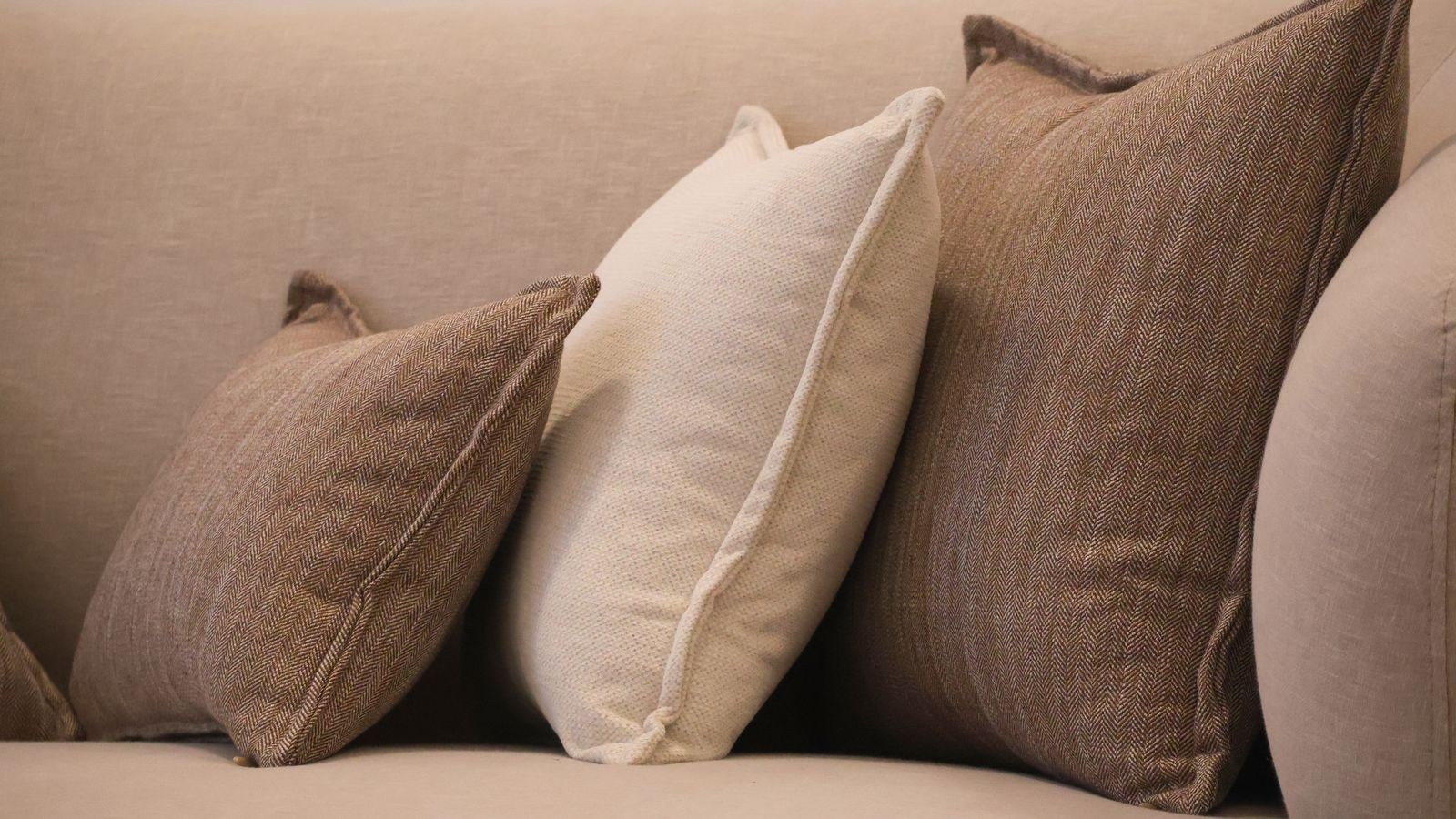 Comfortable sofa with brown and beige throw pillows in neutral tones