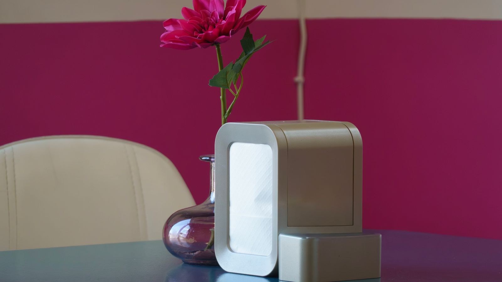 Sleek modern air purifier in an elegant interior next to a vase of flowers