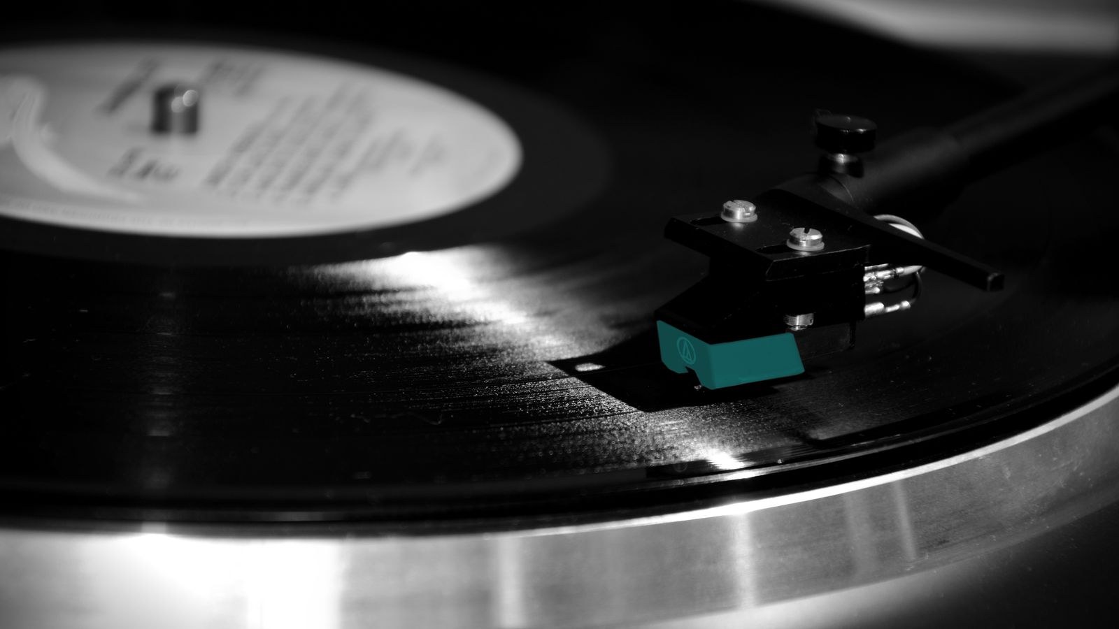 Belt drive turntable playing a vinyl record on a shelf