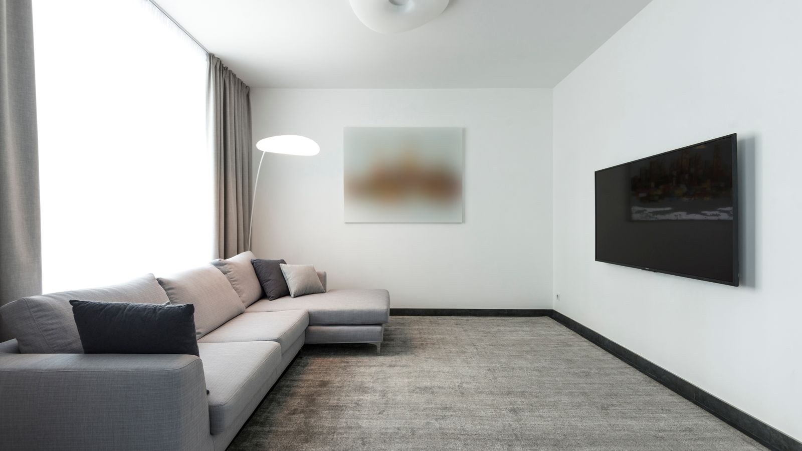 Contemporary living room with a large wall-mounted TV and sectional sofa