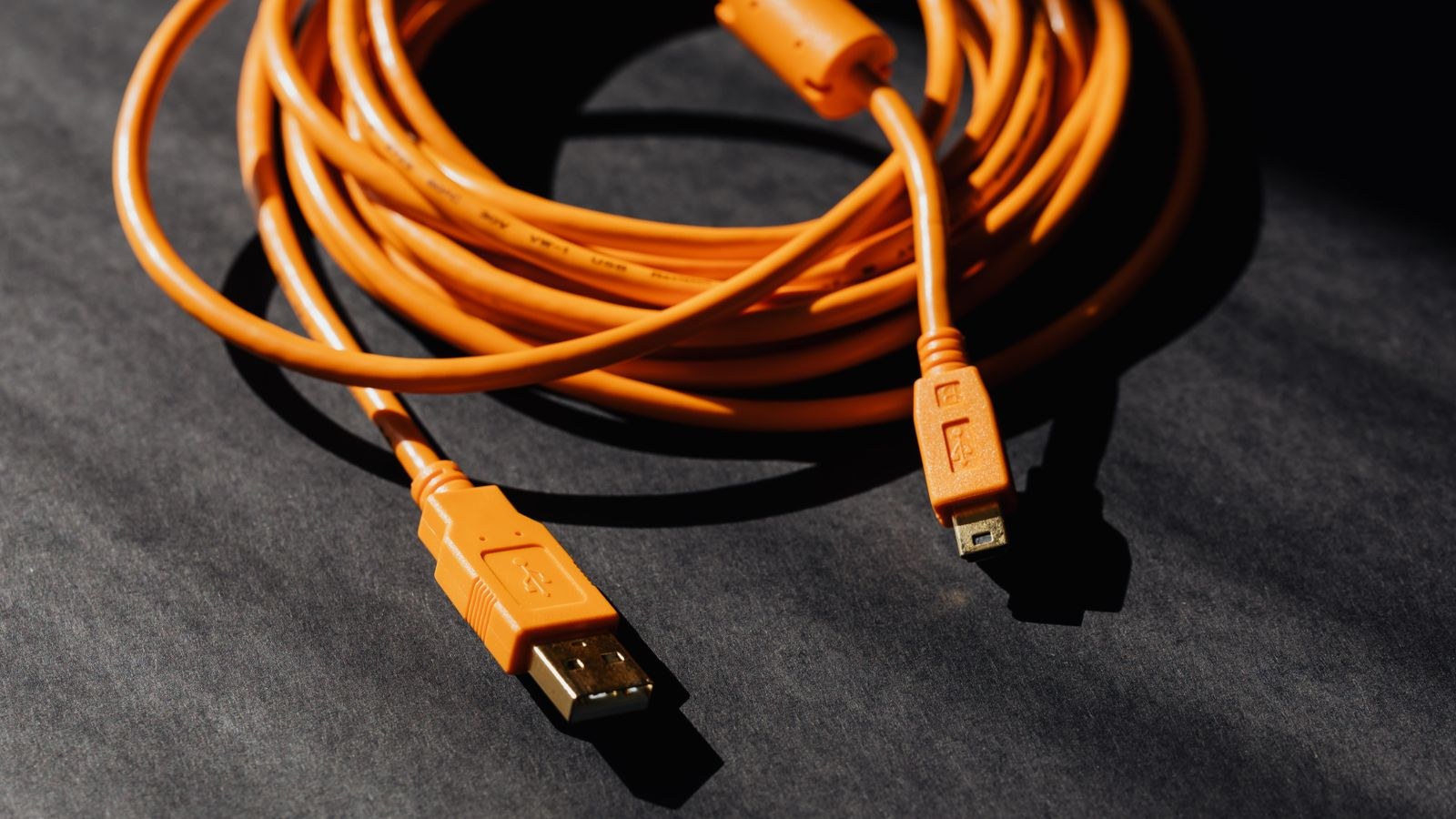 Orange USB cable coiled into a ring viewed from above