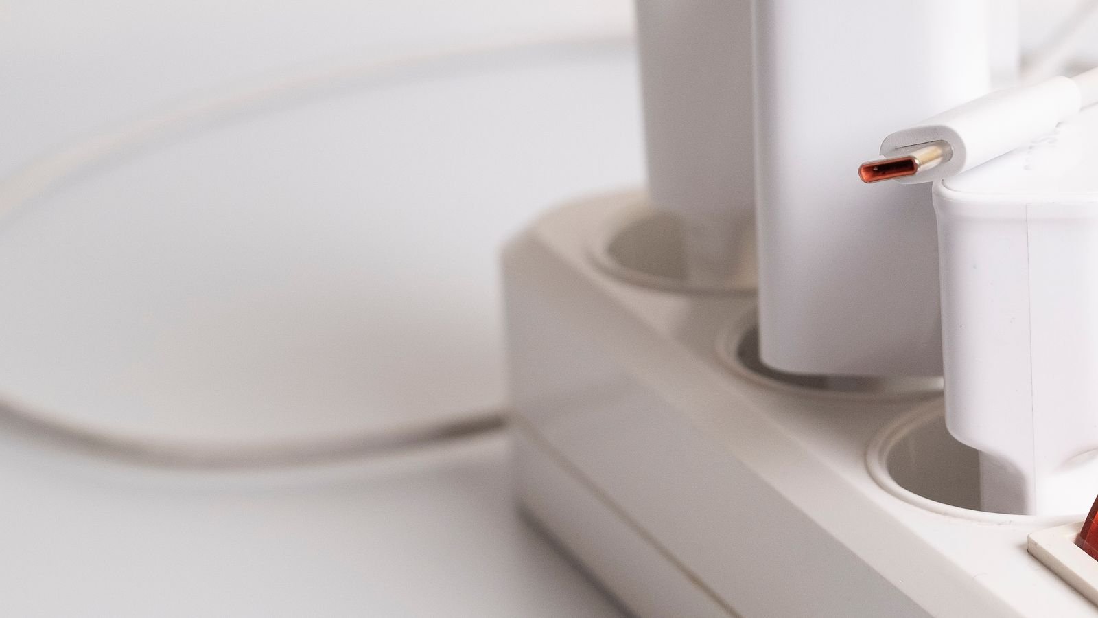 Row of white USB charging plugs arranged on a clean surface