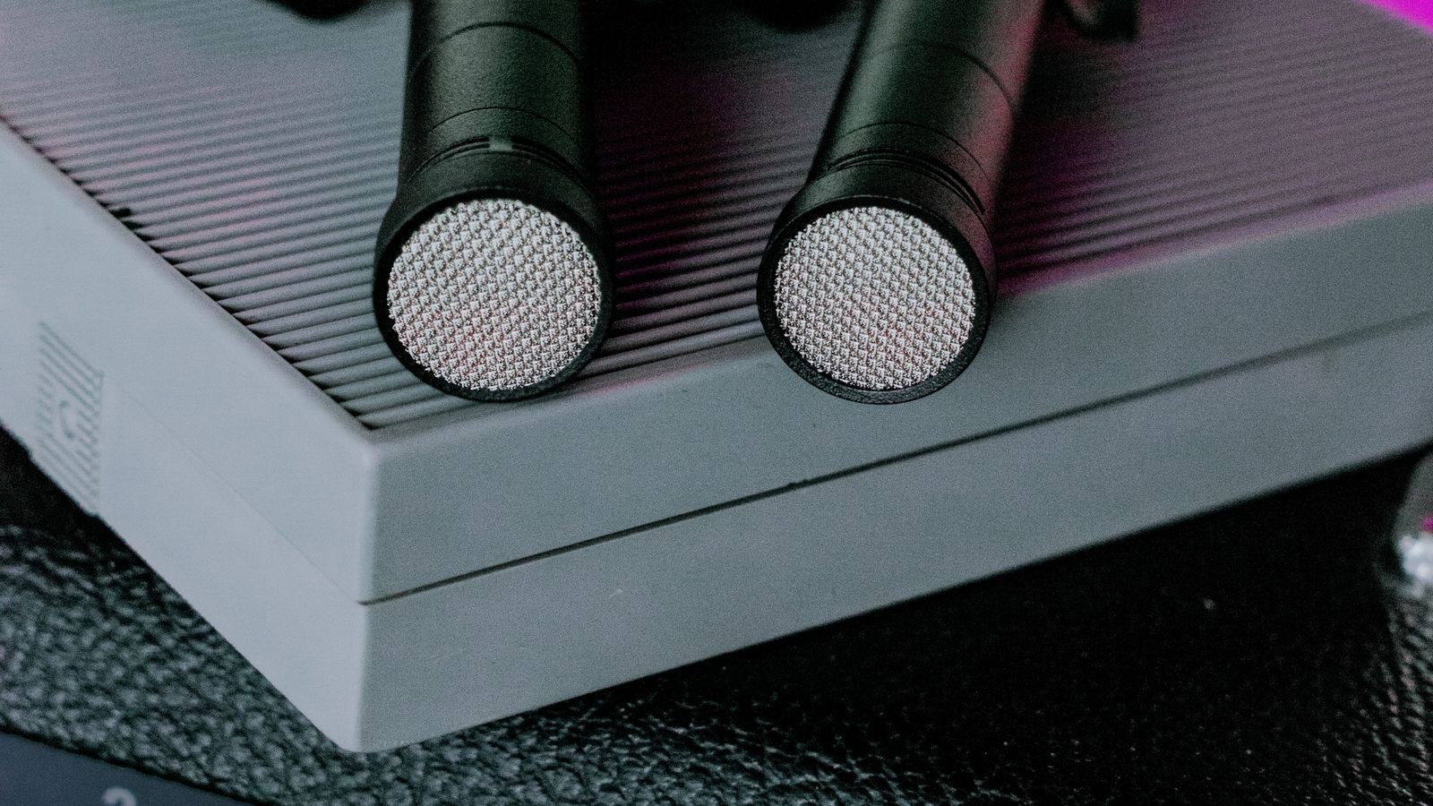 Condenser microphones and audio equipment lit with colourful background lighting