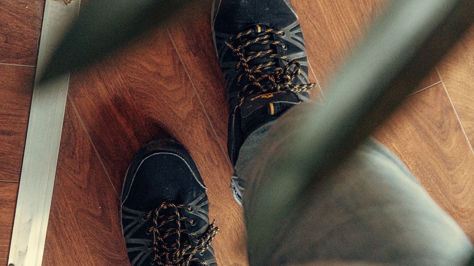 Supportive shoes standing on a wooden floor beside a home office desk