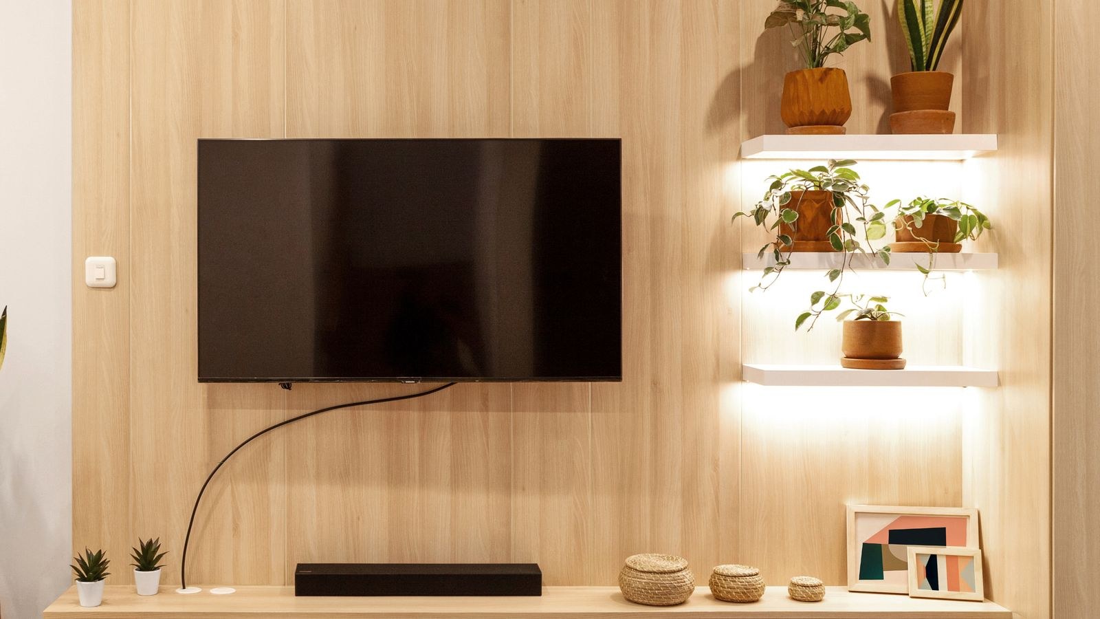 Living room with a wall mounted TV and coaxial wall outlet for a MoCA network