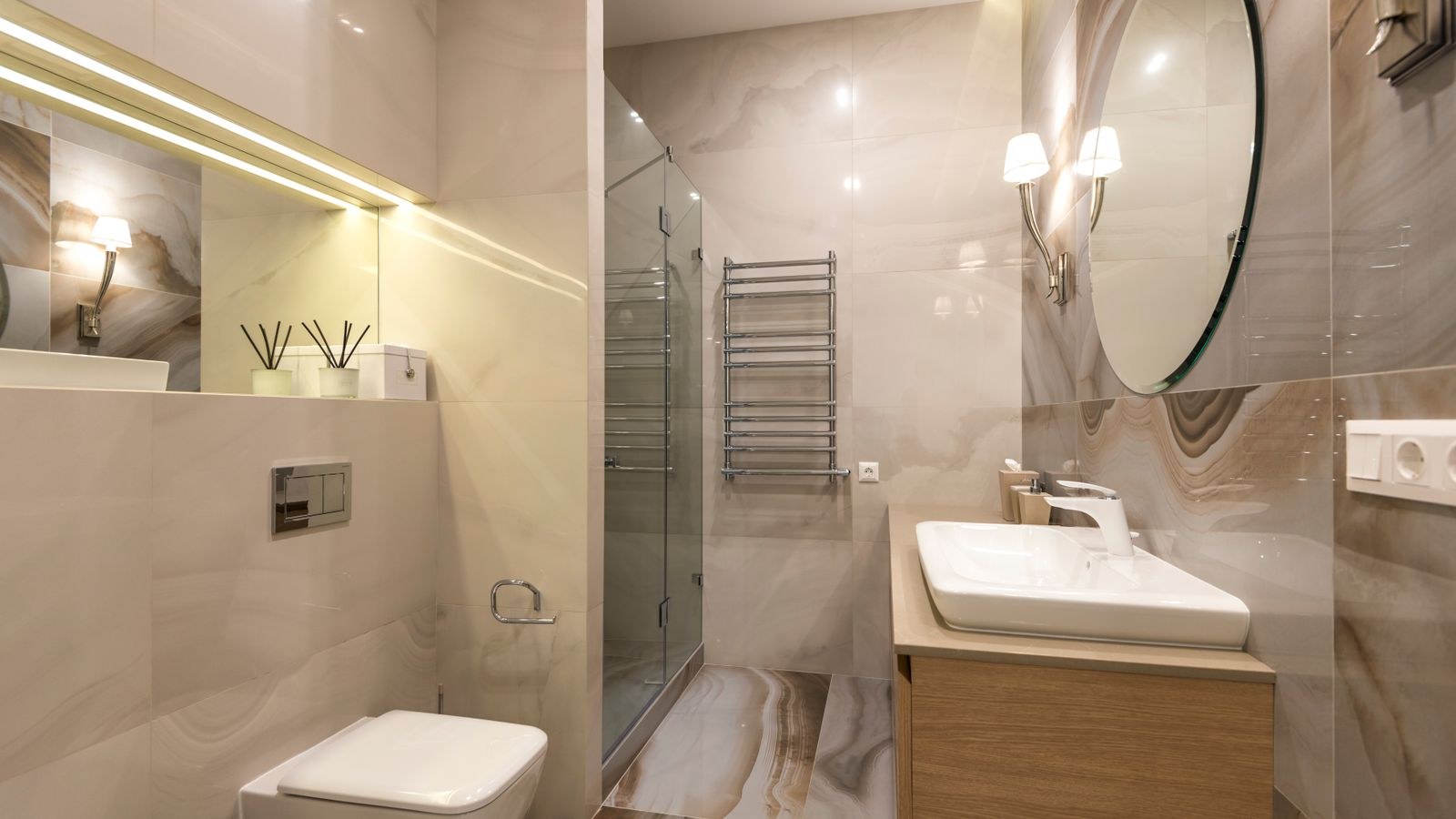 Bathroom mirror flanked by side wall sconces at eye level