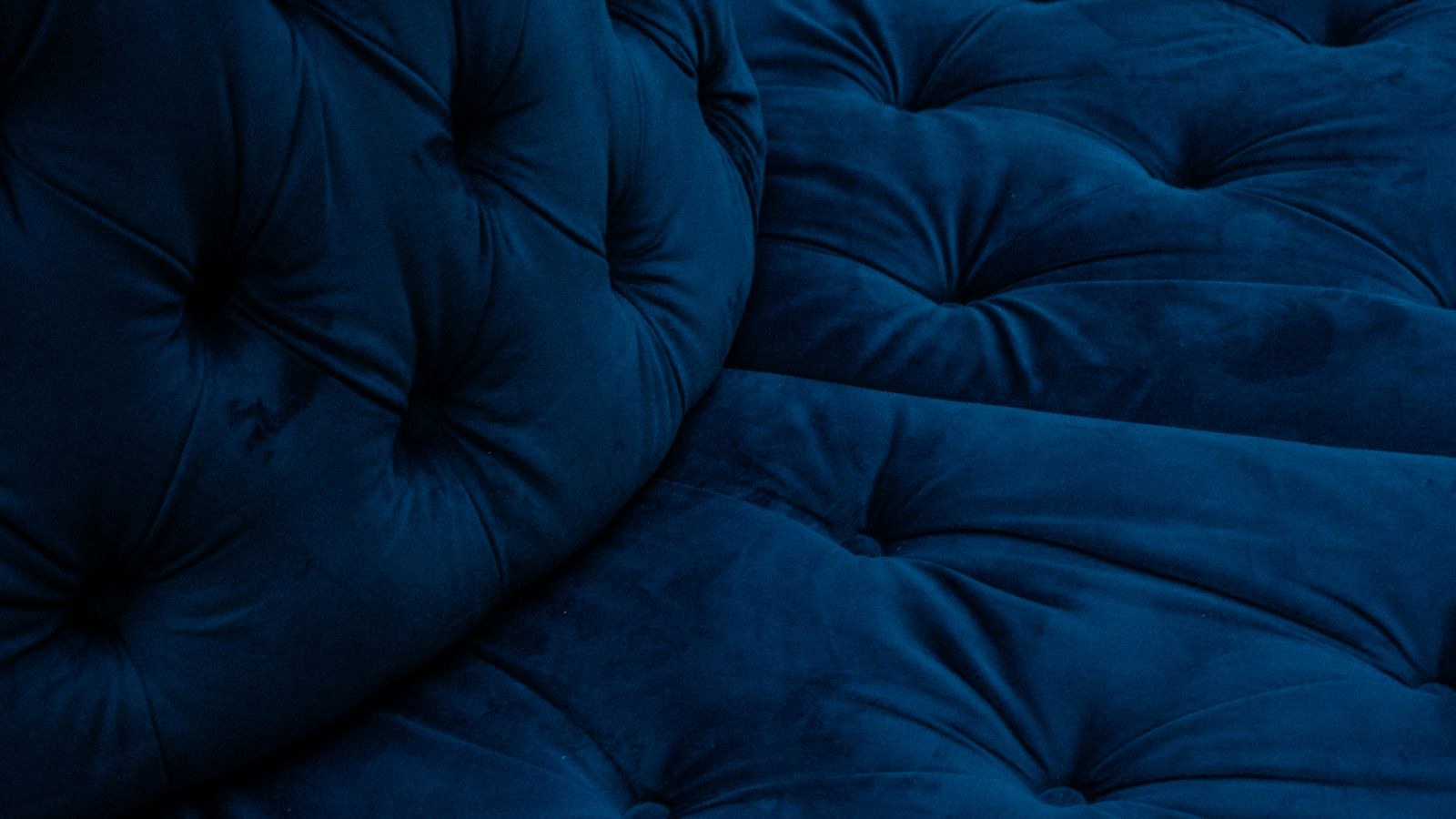Close-up of plush blue velvet cushion texture on a sofa