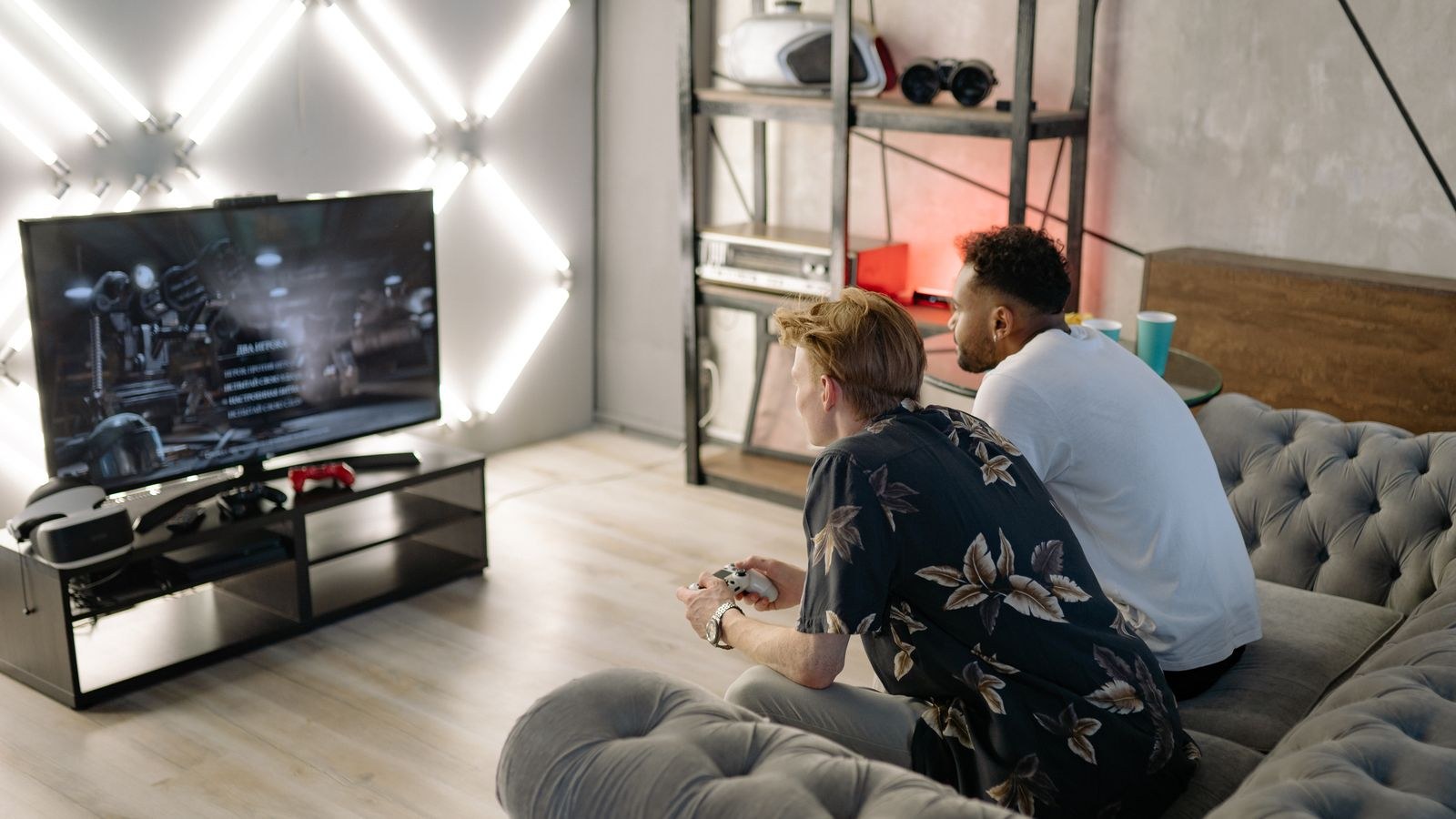 Two people playing video games on a large TV in a modern living room