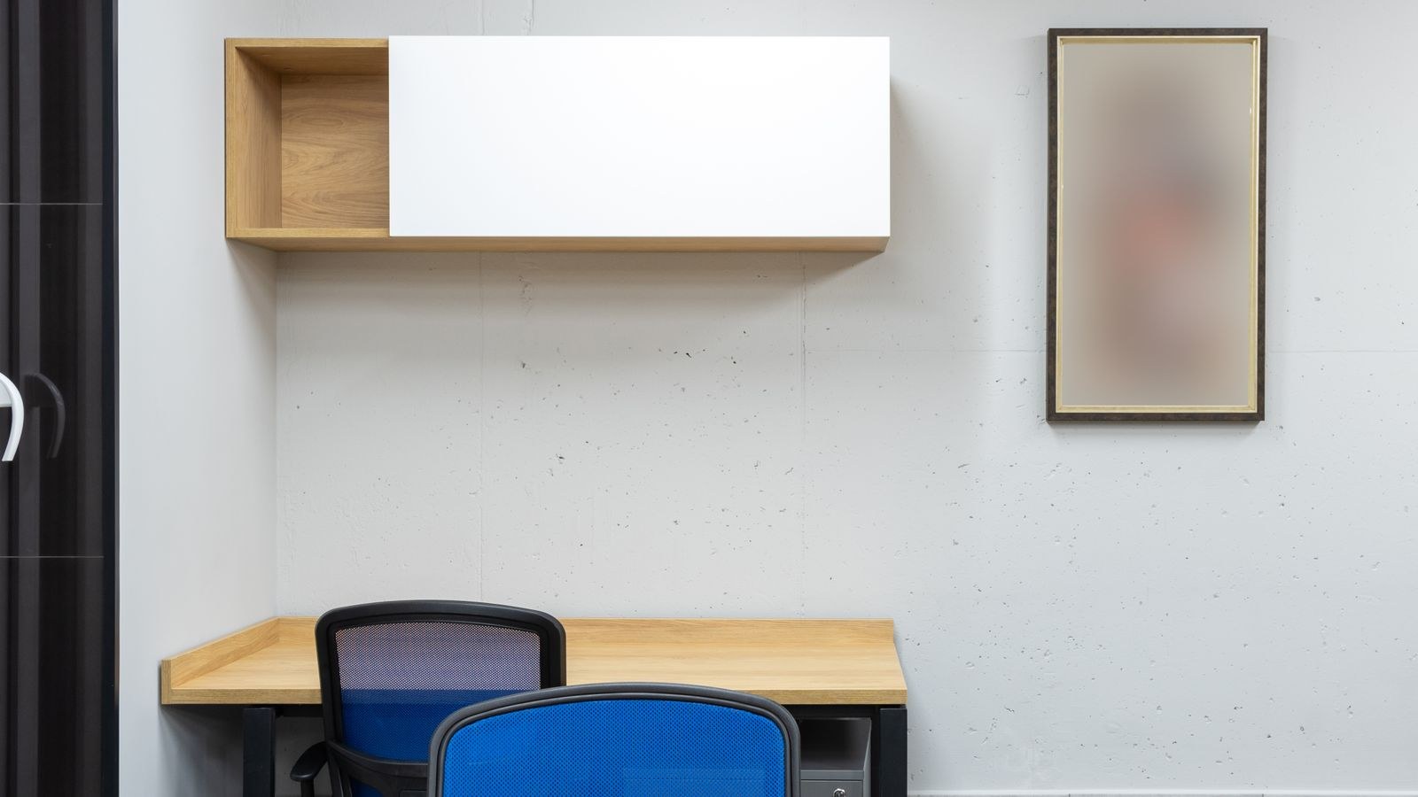 Wall mounted work surface with shelving above in a modern office space