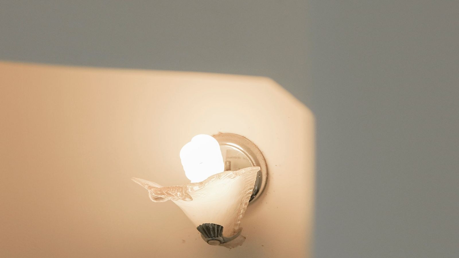 Wall sconce casting soft ambient light on a minimalist painted wall