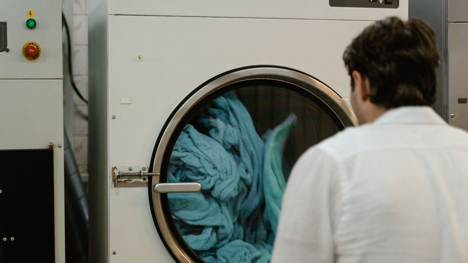 Folded laundry and clothing beside a washing machine drum