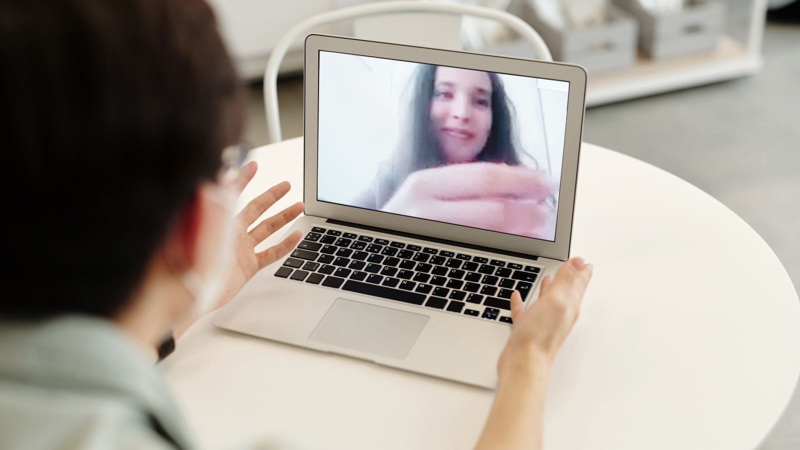 Person on a laptop video call in a tidy home workspace