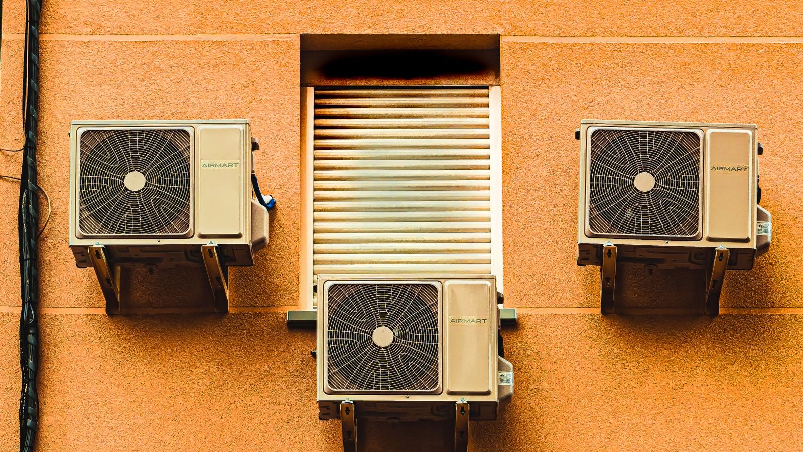 Exterior wall with three window air conditioning units on a modern building