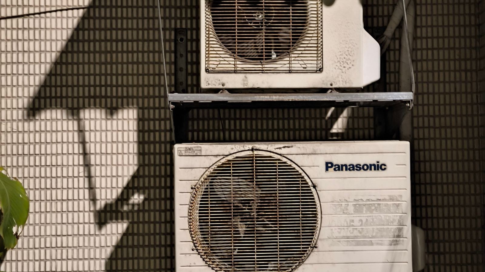 Close-up of two air conditioning units on a building facade in bright sunlight
