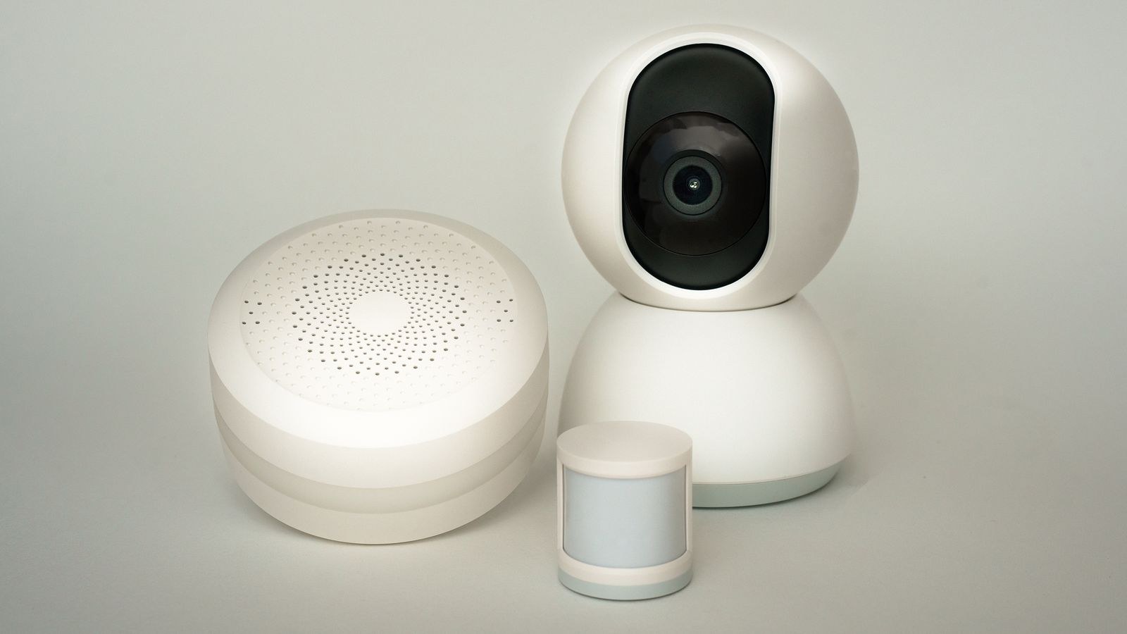 Smart home security sensors and camera arranged on a neutral background