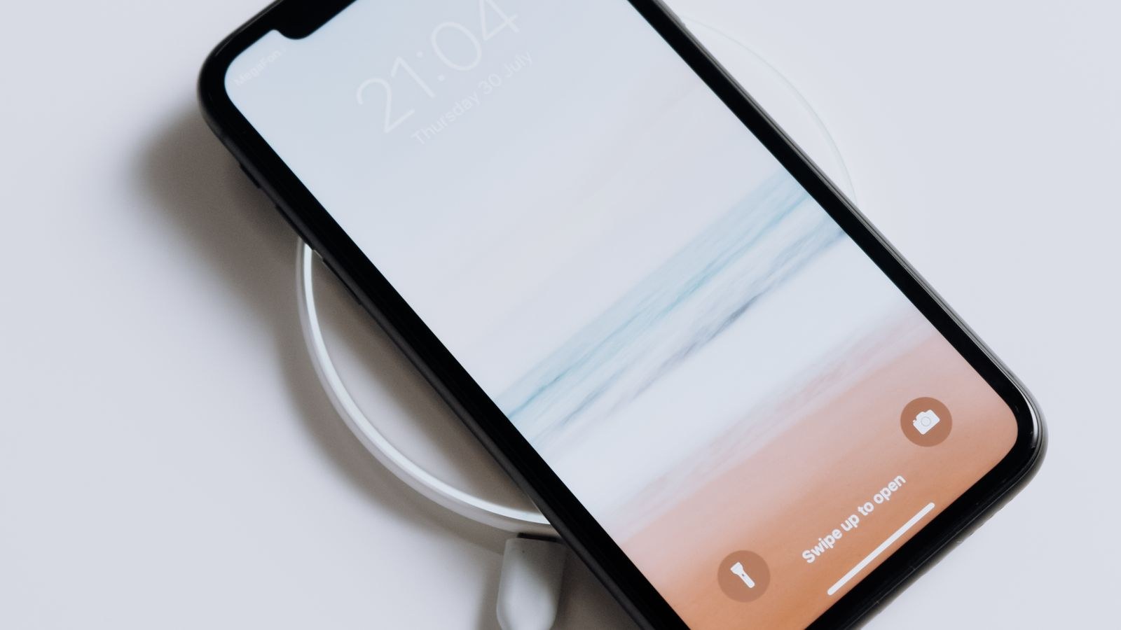 Sleek smartphone charging wirelessly showing a minimalist modern charging setup