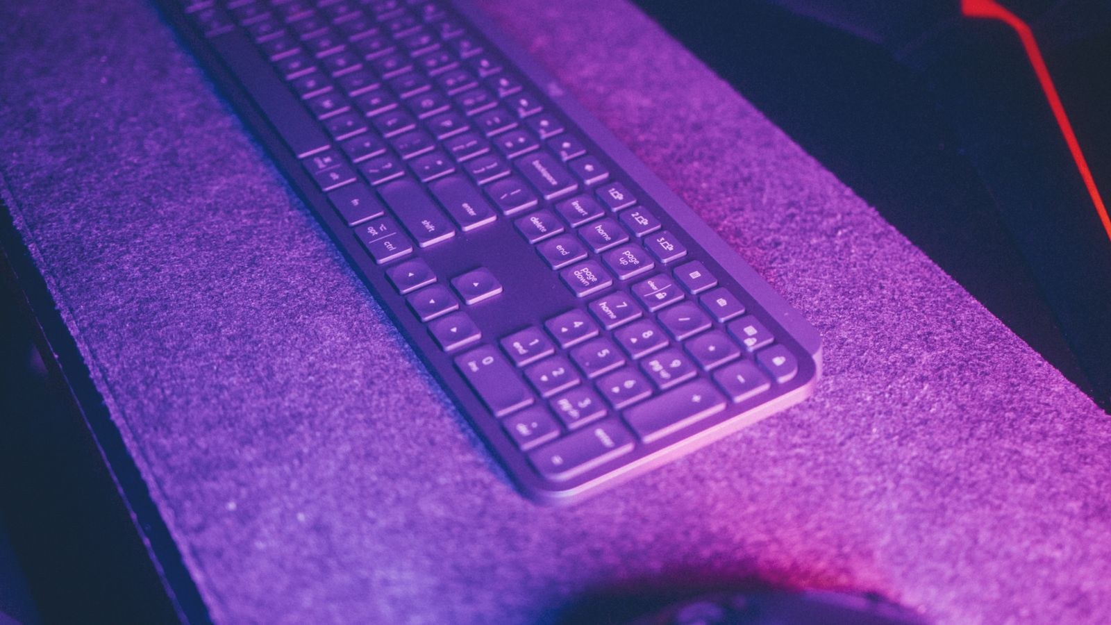 Sleek wireless keyboard and mouse on a modern desk with ambient lighting