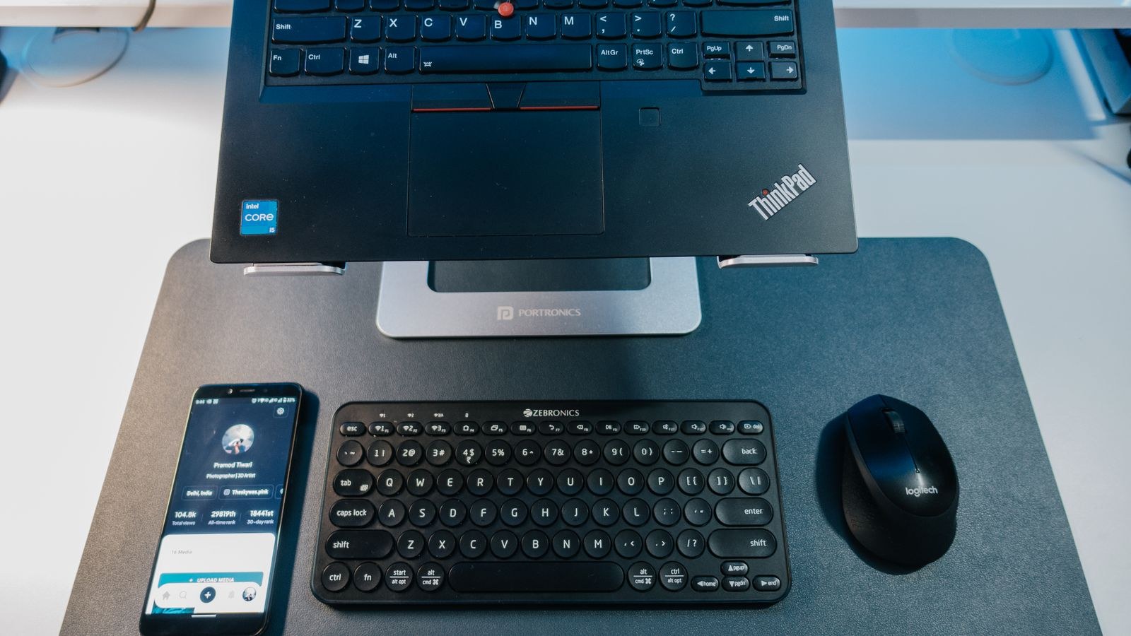 Desk with laptop Bluetooth keyboard smartphone and mouse arranged neatly